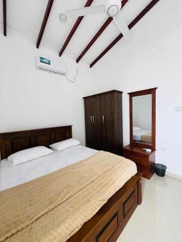 a bedroom with a bed and a mirror at Celestial Negombo Villa 41 in Negombo