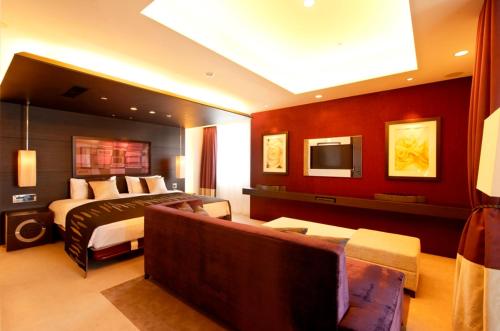a bedroom with a bed and a couch in a room at Kokusai 21 International Hotel in Nagano