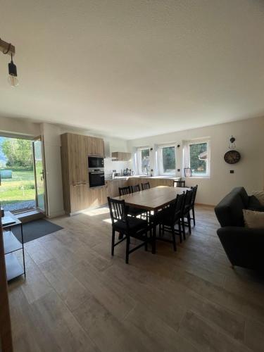un salon avec une table et des chaises et une cuisine dans l'établissement Cozy & modern apartment, à Samoëns
