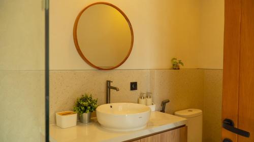 a bathroom with a sink and a mirror at Adya Villa in Nusa Dua