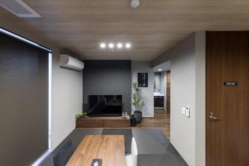 a living room with a table and a television at Culture villa HANEDA in Tokyo