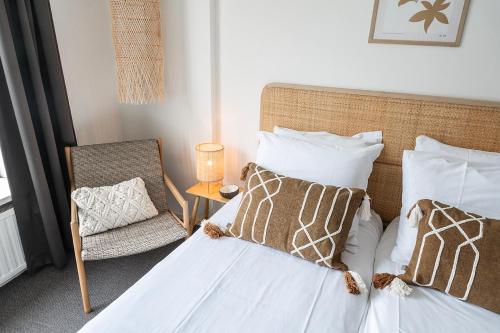 a bedroom with a bed and a chair and a lamp at Beach Stay 1 Min Walk in Zoutelande