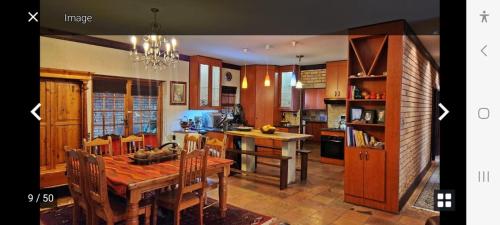 een keuken met een tafel en een eetkamer bij Kamga House in Bloemfontein