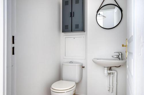 une salle de bain avec toilettes, lavabo et miroir dans l'établissement magnificent studio2CheckProfile, à Paris