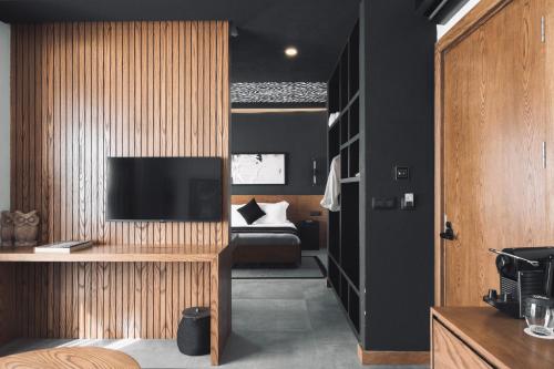 a bedroom with a bed and a television on a wall at The Local House Alaçatı in Alacati