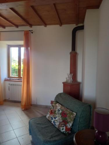a living room with a green couch and a window at Autenticum Agriturismo Tolfa in Tolfa