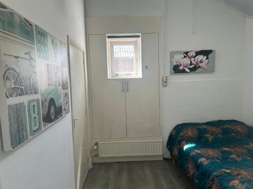 a room with a bed and a door and a window at Zonneoord in Ede