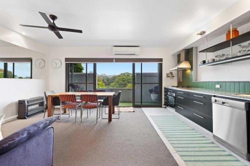 a kitchen with a table and chairs and a dining room at Two-Story Home with 2 Balconies in Sydney