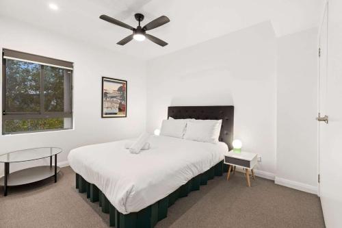a bedroom with a large bed with a ceiling fan at Two-Story Home with 2 Balconies in Sydney