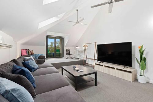 a living room with a couch and a flat screen tv at Two-Story Home with 2 Balconies in Sydney