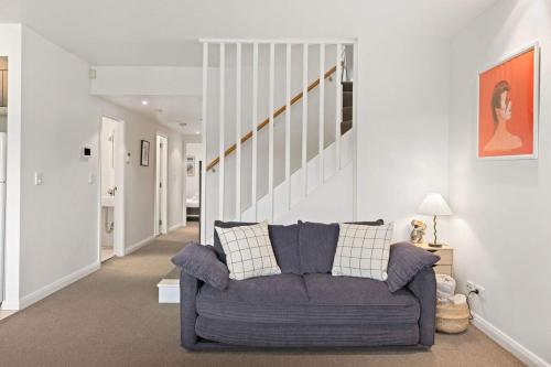 a living room with a purple couch and stairs at Two-Story Home with 2 Balconies in Sydney