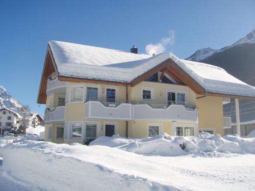 a house is covered in snow with snow at Apart Schultes in Pettneu am Arlberg