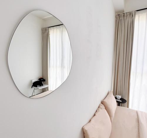 a mirror on a wall in a living room with a couch at Georgetown Seaview & Cityview Childroom Infinity pool with Carpark in Jelutong