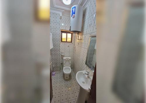 a small bathroom with a sink and a toilet at NEFAR PALACE HOTEL Plc in Bafoussam