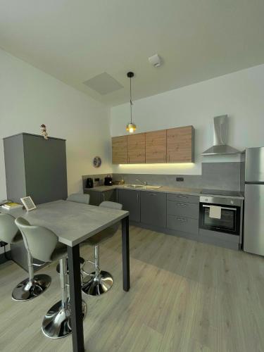 une grande cuisine avec une table et des chaises. dans l'établissement Espace détente Gaudi, à Wittelsheim