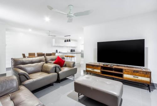 a living room with couches and a flat screen tv at Citi Serviced Apartments - Gaba Place in Port Moresby