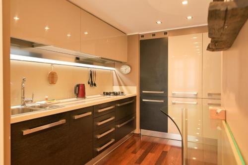a kitchen with a sink and a refrigerator at The Star Loft - A Luxury top floor in Como