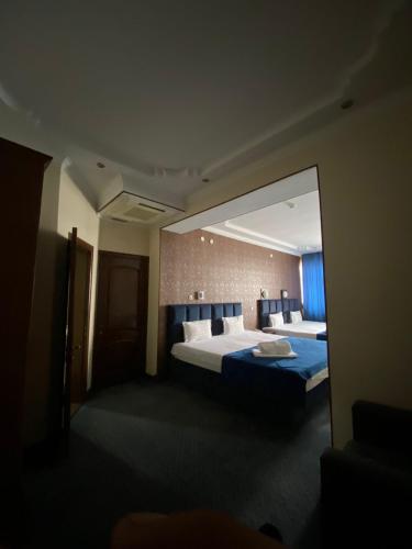 a hotel room with two beds and a large mirror at Sary Arka Hotel in Shymkent