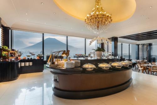 a restaurant with a bar with a chandelier at Mustika Yogyakarta Resort and Spa in Yogyakarta