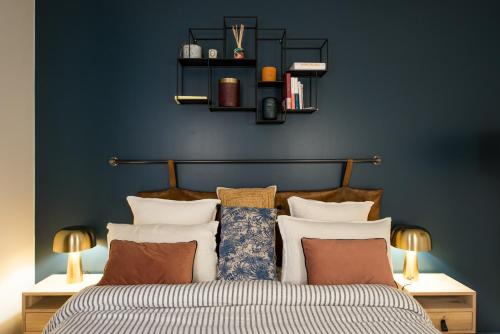 a bedroom with blue walls and a bed with pillows at Magnifique appartement central 3 chambres / 3 BDR in Paris