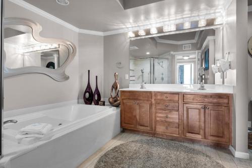 a bathroom with a tub and a large mirror at St. Lucia 1103 in Destin