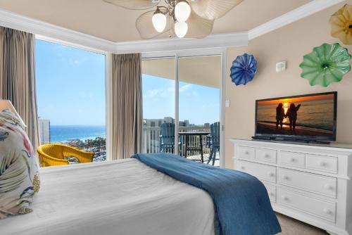 a bedroom with a bed with a television and a balcony at St. Lucia 1103 in Destin