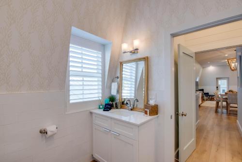 een witte badkamer met een wastafel en een spiegel bij Custom House Inn All in Key West