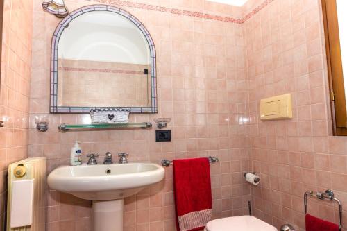 a bathroom with a sink and a toilet and a mirror at Casa Vacanza Anna Maria in Clusane sul Lago