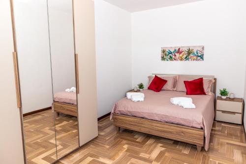 a bedroom with a bed with red pillows and a mirror at Casa Vacanza Anna Maria in Clusane sul Lago