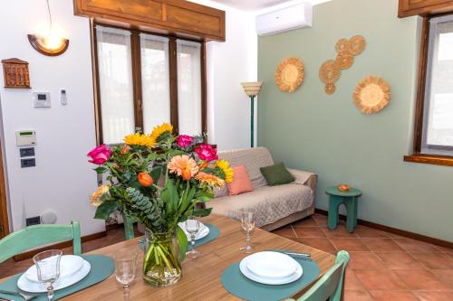 a living room with a table with a vase of flowers at Casa Vacanza Anna Maria in Clusane sul Lago