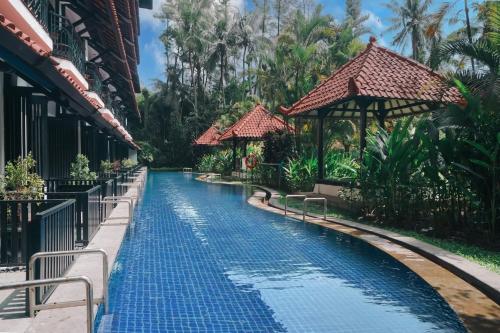 a swimming pool at a resort with a resort at Mustika Yogyakarta Resort and Spa in Yogyakarta