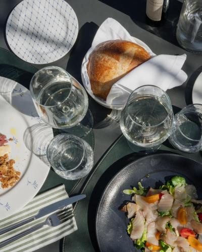 a table with plates of food and glasses of water at Hotel Piccola Vela in Desenzano del Garda