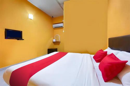 a bedroom with a large bed with red pillows at Coop Hotel Kangar in Kangar