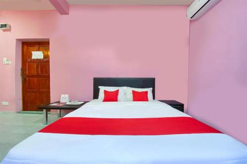 a bedroom with a large bed with red pillows at Coop Hotel Kangar in Kangar