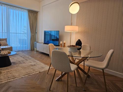 a living room with a table and chairs and a television at New Renovated Stylish 1 Br Dubai View 73 Floor in Dubai