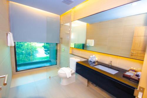 un bagno con un water, un lavandino e una finestra di The Grand Chaiyapruek Nimman Chiangmai a Chiang Mai