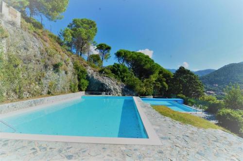 a swimming pool in front of a mountain at Excelsior Relaxing Apartment in Levanto