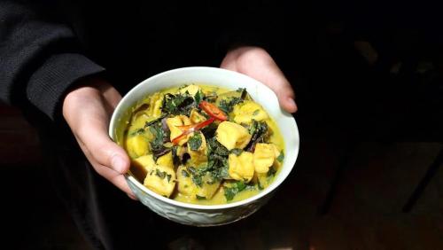 a person is holding a bowl of food at Yên homestay in Hoi An