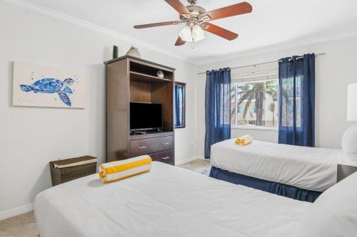 a bedroom with two beds and a ceiling fan at Palm Cay 5 in Holmes Beach