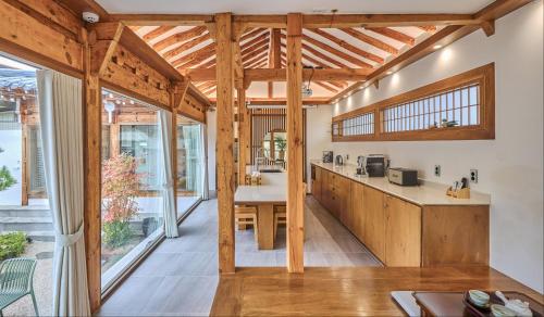 a kitchen with wooden cabinets and a large window at Korean Chalet 소연정 Hanok stay in Andong