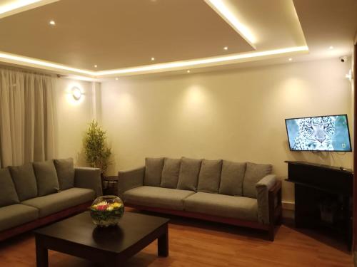 a living room with a couch and a flat screen tv at Lukenya Alkebu Resort in Nairobi