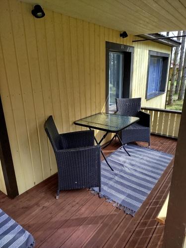 a patio with a table and chairs on a deck at Reinholdi metsamaja in Jabara