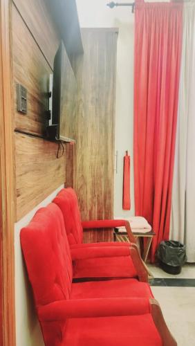 a red couch in a living room with a red curtain at Eastern Lodge Guest House in Dargai