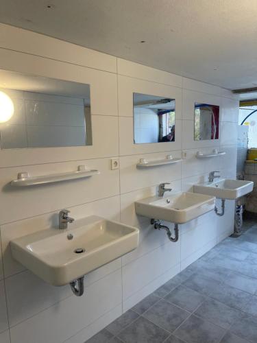 a bathroom with two sinks and two mirrors at Luxushütte Welgelegen in Bestwig
