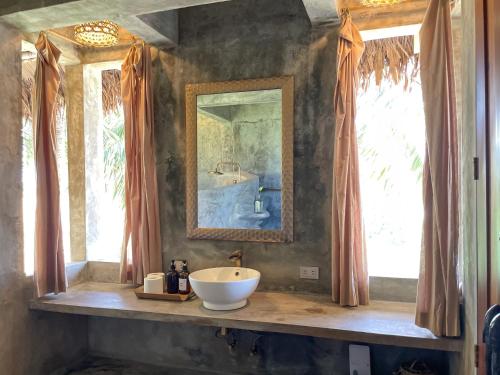 a bathroom with a sink and a mirror at Baia Nest TURINGAN Loft, Self-Service Breakfast, Near the Beach, Pet Friendly with a Fee in Gubat