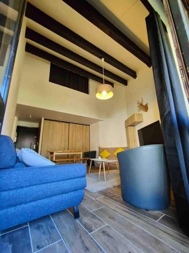 un salon avec un canapé bleu et une table dans l'établissement Appartement cocooning, aux Angles