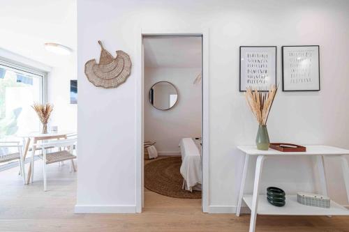 Cette chambre blanche dispose d'une table et d'un miroir. dans l'établissement Charmant 2 Pièces à 10 min du Palais des Festivals, à Cannes