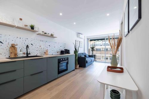 Il comprend une cuisine et un salon doté d'un canapé bleu. dans l'établissement Charmant 2 Pièces à 10 min du Palais des Festivals, à Cannes