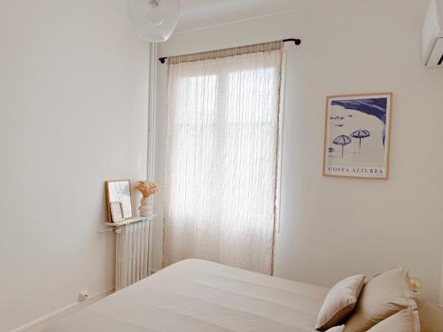 une chambre blanche avec un lit et une fenêtre dans l'établissement Ker Riviera, à Nice