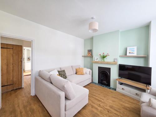 a living room with a white couch and a tv at Cosy Cottage in Broadstairs in Broadstairs
